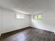 A well-lit bedroom with wood floors, natural light, and clean neutral color walls at 7206 Ashwood Dr, Port Richey, FL 34668