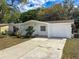 Charming home with a well-maintained front yard and long driveway leading to an attached single car garage at 7206 Ashwood Dr, Port Richey, FL 34668