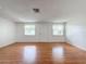 Open living room area with natural light from two windows and a white front door entrance at 7206 Ashwood Dr, Port Richey, FL 34668