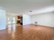 Spacious living room with hardwood floors and neutral walls, transitioning to a tiled kitchen area at 7206 Ashwood Dr, Port Richey, FL 34668