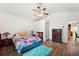 Bright bedroom with floral bedding, wood dresser, and view of kitchen at 1641 Bayfield Ct, Trinity, FL 34655