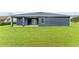 House back view, showcasing a covered patio and spacious backyard at 5406 Boxtree Ct, Dade City, FL 33523