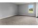 Grey bedroom with carpet and large window at 5406 Boxtree Ct, Dade City, FL 33523