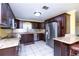 Modern kitchen with dark wood cabinets, granite countertops and stainless steel appliances at 24514 Audubon Dr, Brooksville, FL 34601
