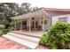 Covered patio with seating area, adjacent to the house and lush greenery at 24514 Audubon Dr, Brooksville, FL 34601