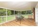 Relaxing screened porch with wooden deck and table at 24514 Audubon Dr, Brooksville, FL 34601