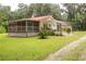 Ranch home with red metal roof, screened porch, and large deck at 24514 Audubon Dr, Brooksville, FL 34601
