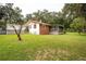 Brick house exterior with red roof, screened porch and landscaped yard at 24514 Audubon Dr, Brooksville, FL 34601