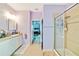 Bright bathroom showcasing a shower, double vanity and a view into the Primary bedroom at 11143 Merganser Way, New Port Richey, FL 34654