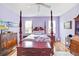 Primary bedroom showing four-poster bed, dresser, and modern interior design at 11143 Merganser Way, New Port Richey, FL 34654