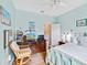 Comfortable bedroom with blue walls features ceiling fan, wood floors, and a quaint desk area at 11143 Merganser Way, New Port Richey, FL 34654