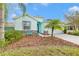 Light teal house with landscaping, driveway, and palm trees at 11143 Merganser Way, New Port Richey, FL 34654
