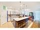 Spacious kitchen features an island, white cabinets with blue trim, tile backsplash, and dining area at 11143 Merganser Way, New Port Richey, FL 34654