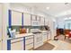 Bright kitchen area with white appliances, tile countertops, backsplash, and ample storage at 11143 Merganser Way, New Port Richey, FL 34654