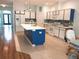 Spacious kitchen features an island, white cabinets with blue trim, tile backsplash and stainless appliances at 11143 Merganser Way, New Port Richey, FL 34654