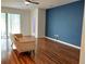 Living room with laminate flooring, a blue accent wall, and sliding glass door at 11143 Merganser Way, New Port Richey, FL 34654