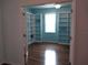 Bright office space featuring custom wall shelving, hardwood floors, natural light, and french doors at 11143 Merganser Way, New Port Richey, FL 34654
