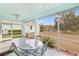 Screened porch overlooking landscaped backyard with a pond view and metal table with four chairs at 11143 Merganser Way, New Port Richey, FL 34654