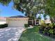 Charming single-story home with a well-manicured lawn, mature trees, and an attached two-car garage at 13626 Bryndlewood Ct, Hudson, FL 34669