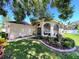 Beautiful single-story home with arched windows, a manicured lawn, and fresh landscaping at 13626 Bryndlewood Ct, Hudson, FL 34669