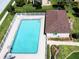 Aerial view of a sparkling pool with a gated fence, pool house, and surrounding greenery at 13626 Bryndlewood Ct, Hudson, FL 34669