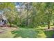 Lush backyard with mature trees and lawn offering a private and serene outdoor space, ideal for relaxation at 3605 Kings Rd # 102, Palm Harbor, FL 34685