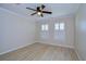 Empty bedroom with hardwood floors, white trim, and two windows at 3605 Kings Rd # 102, Palm Harbor, FL 34685