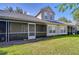 View of the home's backyard with a screened patio and green lawn at 3605 Kings Rd # 102, Palm Harbor, FL 34685