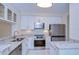 The well-lit kitchen features granite countertops, stainless steel appliances, and modern white cabinetry at 3605 Kings Rd # 102, Palm Harbor, FL 34685