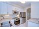 This kitchen features white cabinets, stainless steel appliances, and granite countertops at 3605 Kings Rd # 102, Palm Harbor, FL 34685