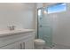 Bright bathroom featuring white vanity, toilet, and glass enclosed shower with modern fixtures at 3898 Southern Valley Loop, Brooksville, FL 34601