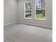 Serene bedroom with two windows overlooking the lawn and plush gray carpet at 3898 Southern Valley Loop, Brooksville, FL 34601