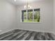 Bright dining area with wood-look flooring, modern lighting, and a large window offering a pleasant view at 3898 Southern Valley Loop, Brooksville, FL 34601