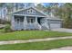 Inviting craftsman style home featuring a cozy front porch with stone accents and a well-maintained lawn at 3898 Southern Valley Loop, Brooksville, FL 34601