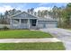 Charming single-Gathering home showcasing a craftsman style exterior, well-manicured lawn, and a spacious three car garage at 3898 Southern Valley Loop, Brooksville, FL 34601