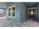 The covered front porch features brick flooring leading to the entry door and exterior architecture at 3898 Southern Valley Loop, Brooksville, FL 34601
