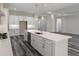 A well-lit kitchen with an island, stainless steel appliances, bright white cabinets, and modern wood-look flooring at 3898 Southern Valley Loop, Brooksville, FL 34601