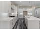 Modern kitchen with stainless steel appliances, white cabinets, a center island with a sink and dark wood flooring at 3898 Southern Valley Loop, Brooksville, FL 34601