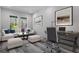 Staged office/living room with gray wood flooring and windows overlooking greenery at 3898 Southern Valley Loop, Brooksville, FL 34601