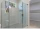 Modern bathroom featuring glass-enclosed shower with gray tile, built-in shelf and window at 3898 Southern Valley Loop, Brooksville, FL 34601
