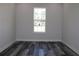 Bright bedroom features gray laminate wood flooring, neutral walls and large windows offering views of the neighborhood at 4676 Hickory Oak Dr, Brooksville, FL 34601