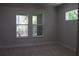 Cozy bedroom boasts soft carpeting and features bright, oversized windows overlooking lush greenery and natural light at 4676 Hickory Oak Dr, Brooksville, FL 34601
