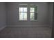 Cozy bedroom boasts soft carpeting and features bright, oversized windows overlooking lush greenery and natural light at 4676 Hickory Oak Dr, Brooksville, FL 34601