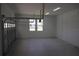 Clean and open two car garage with bright overhead lighting and automatic door opening system at 4676 Hickory Oak Dr, Brooksville, FL 34601