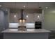 Kitchen view with large island with quartz countertop, white cabinets, and stainless steel vent hood at 4676 Hickory Oak Dr, Brooksville, FL 34601