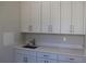 Well-equipped laundry room with white cabinets, quartz countertop, sink, and chrome faucet at 4676 Hickory Oak Dr, Brooksville, FL 34601