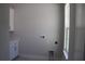 Functional laundry room with white cabinetry, utility connections, and natural light from the window at 4676 Hickory Oak Dr, Brooksville, FL 34601