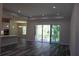Bright living room featuring sliding glass doors, recessed lighting, and modern gray wood-look flooring at 4676 Hickory Oak Dr, Brooksville, FL 34601
