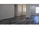 Spacious living room features gray laminate wood flooring and neutral walls at 4676 Hickory Oak Dr, Brooksville, FL 34601
