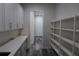 Long view of walk-in pantry featuring white shelving, cabinets, and hard surface floors at 4676 Hickory Oak Dr, Brooksville, FL 34601